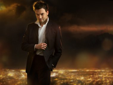 Elegant young handsome man over night city background clipart