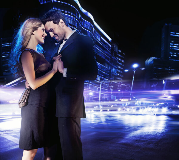 Красивая молодая пара танцует на улице и улыбается
