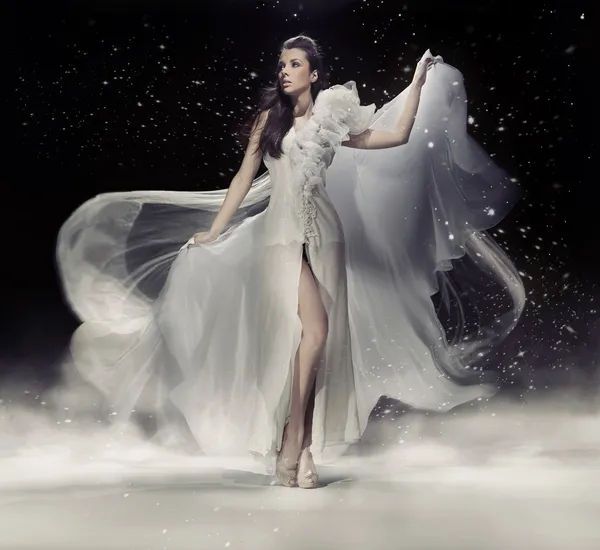 Femme brune sensuelle dansant en robe blanche Photo De Stock