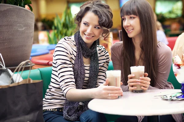 Två vackra kvinnor dricka kaffe och prata — Stockfoto