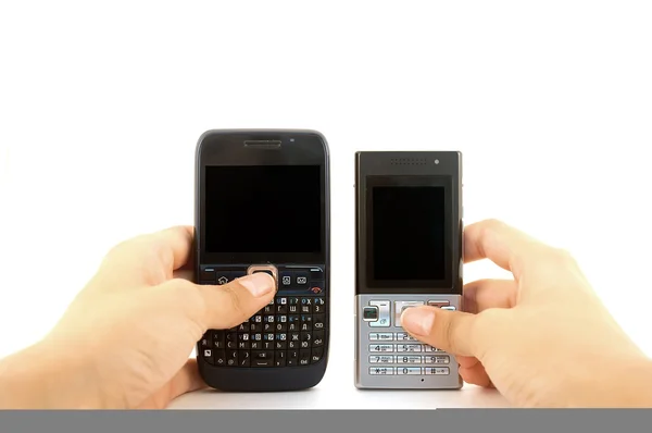 Δύο κινητά τηλέφωνα στα χέρια πάνω από το λευκό — Φωτογραφία Αρχείου