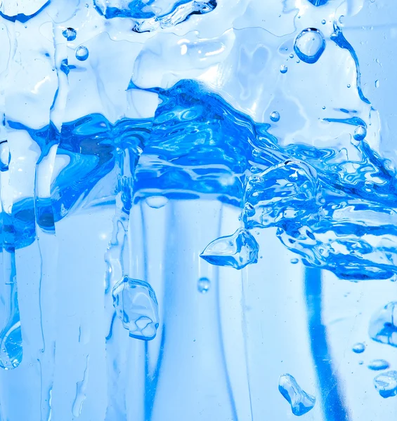 Vonken van het blauwe water op een witte achtergrond — Stockfoto