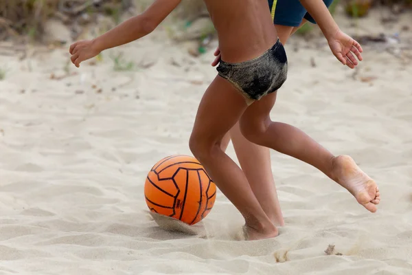 Мальчики играют в пляжный футбол — стоковое фото