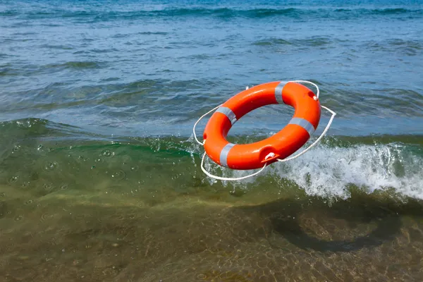 Red lifebuoy flying in the sea wave — Stock Photo, Image