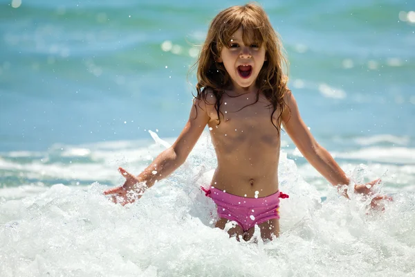 Маленькая девочка в море в солнечный день — стоковое фото
