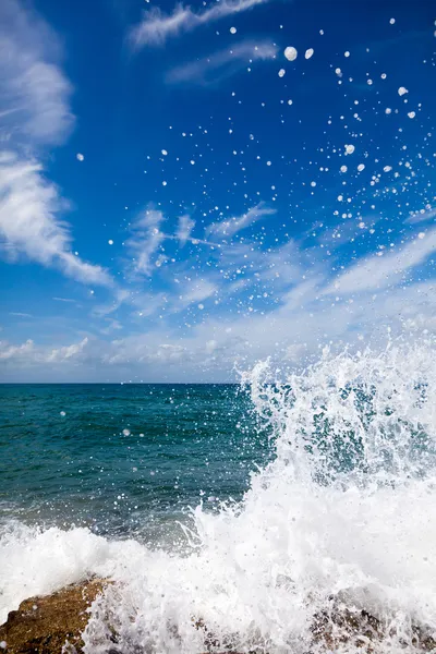 A hullámok megtörnek a köves parton. — Stock Fotó