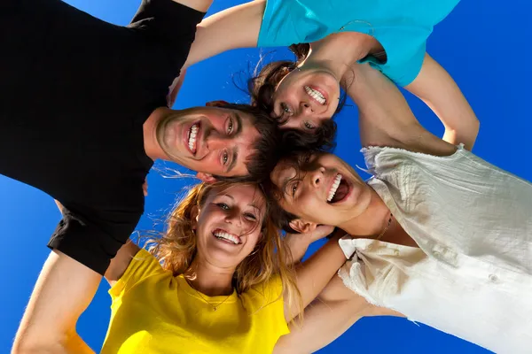 The four friends, embracing, has formed a circle and bent over a — Stock Photo, Image