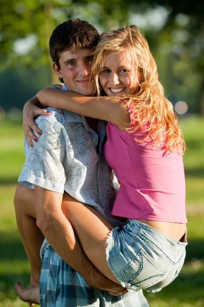 Un couple d'amoureux - un jeune homme tenant une fille sur ses mains — Photo