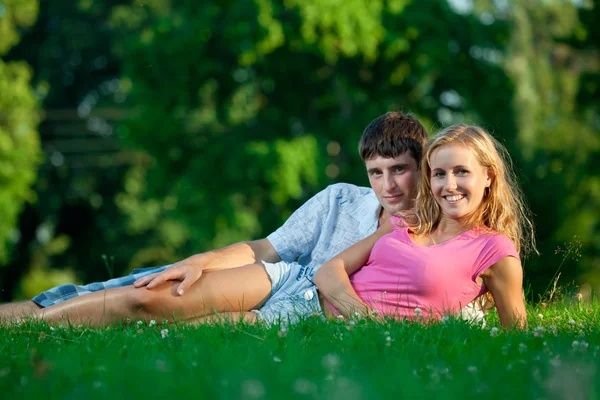 Пара відпочиває на траві в парку — стокове фото