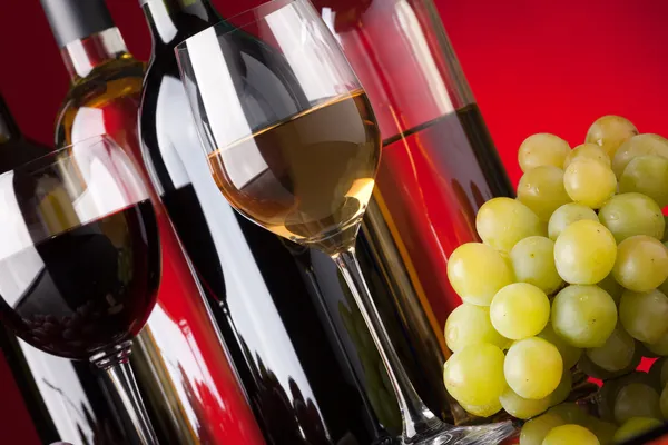 Бутылки, бокалы и виноград — стоковое фото