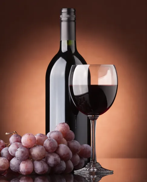 Láhev červeného vína, skla a hrozny — Stock fotografie
