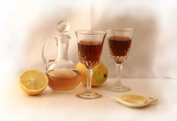 Copas de vino con coñac y limones sobre fondo blanco Imagen De Stock