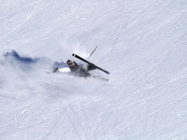 Ein lächelnder Skifahrer stürzt auf der Skipiste. — Stockfoto