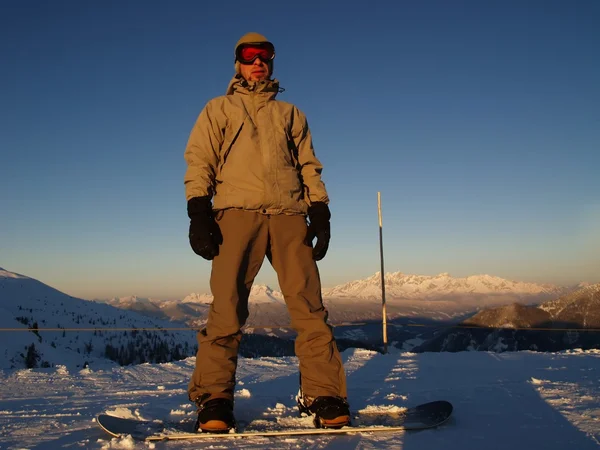 Een snowboarder permanent boven op de heuvel. — Stockfoto