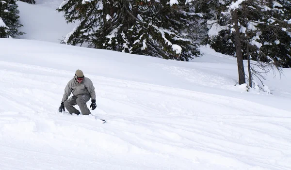 Snowboardista chlap sklouzla ze svahu. — Stock fotografie