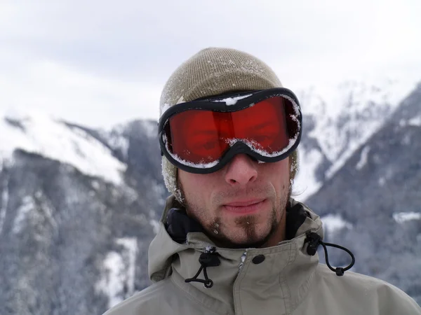 De besneeuwde gezicht van een kerel snowboarder. — Stockfoto