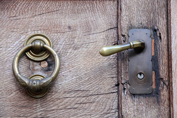 Doorknob and knocker on old wooden door — Stock Photo, Image