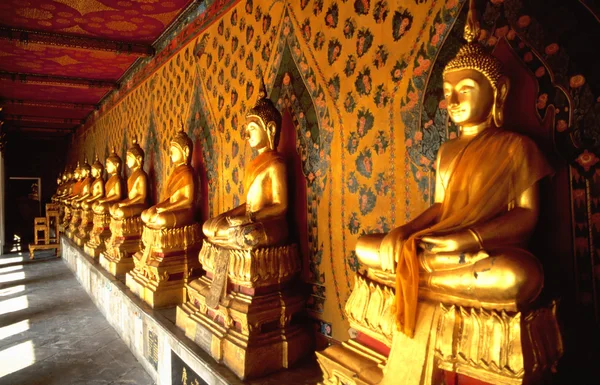 Rij van gouden Boeddha's in Thaise tempel — Stockfoto