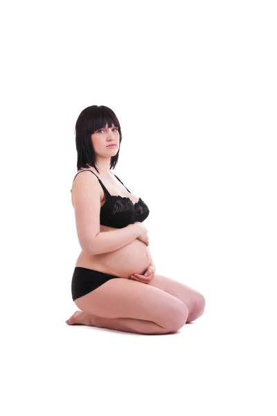 Zwangere jonge vrouw zitten in ondergoed — Stockfoto