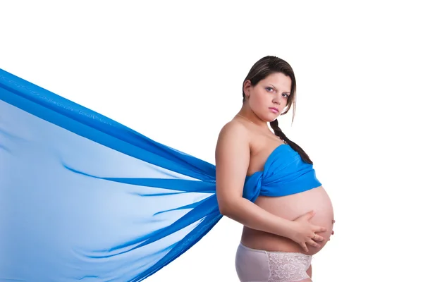 Mujer embarazada en tela azul sosteniendo su vientre — Foto de Stock