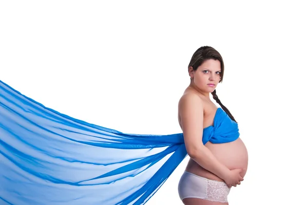 Zwangere vrouw in blauwe stof houden haar buik — Stockfoto