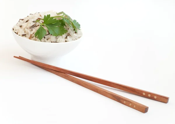 Miska z ugotowanego ryżu i pałeczki do jedzenia w pobliżu — Zdjęcie stockowe