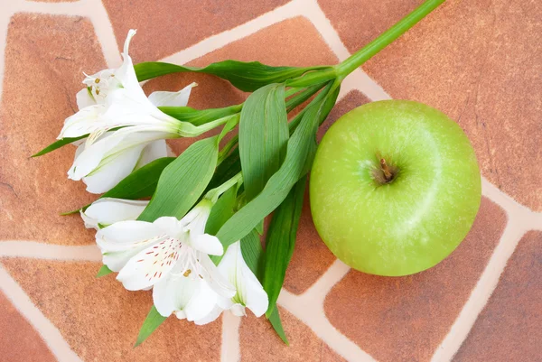 Lily and apple over floor — Stock Photo, Image
