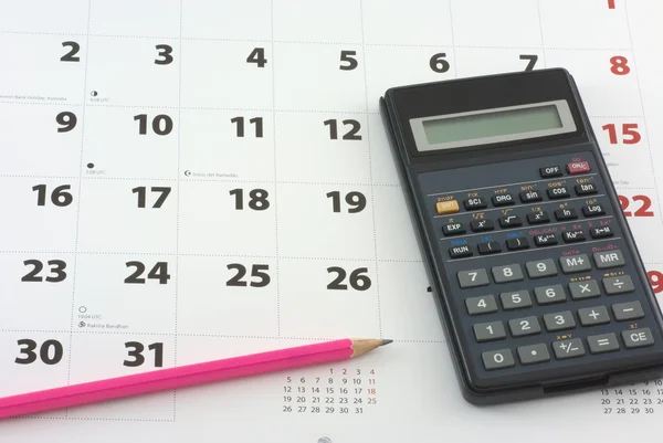 Calcolatrice e matita sul calendario — Foto Stock
