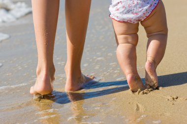 Egs of a wonam walking in water with her baby clipart