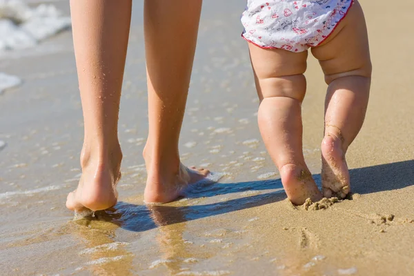 Stock image Egs of a wonam walking in water with her baby