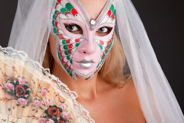 Mooie jonge vrouw dragen van carnaval masker — Stockfoto