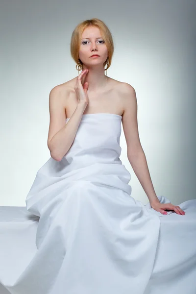 Молодая женщина в полотенце сидит — стоковое фото