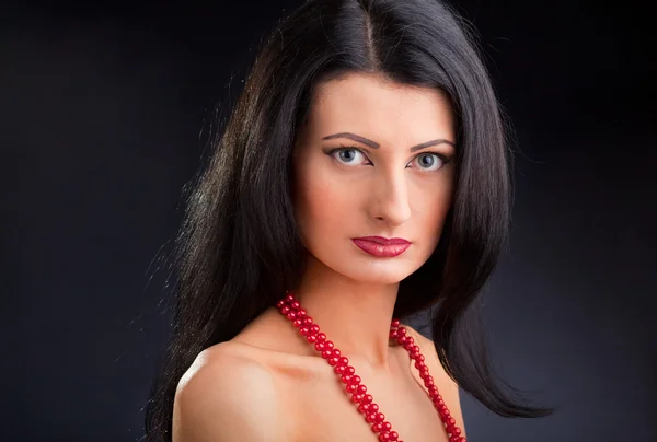 Vackra mörka haired girl med röda pärlor — Stockfoto