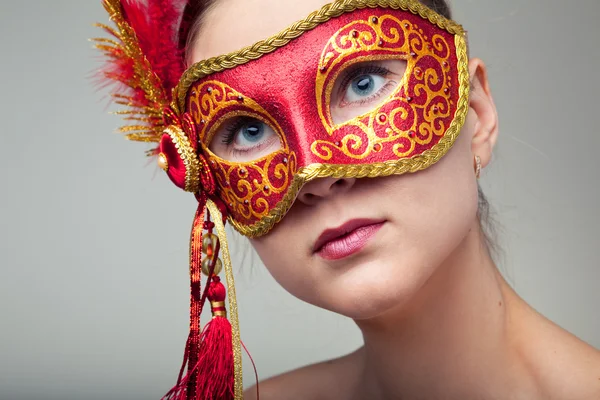 Jolie belle jeune femme portant un masque de carnaval rouge — Photo