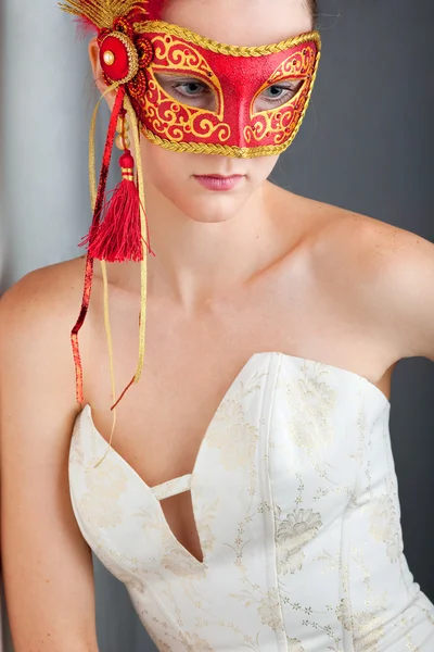 Bella giovane donna indossando maschera carnevale rosso — Foto Stock