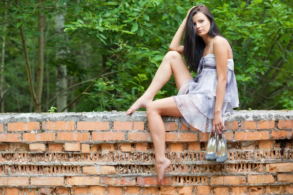 Mädchen sitzt auf alter Mauer — Stockfoto