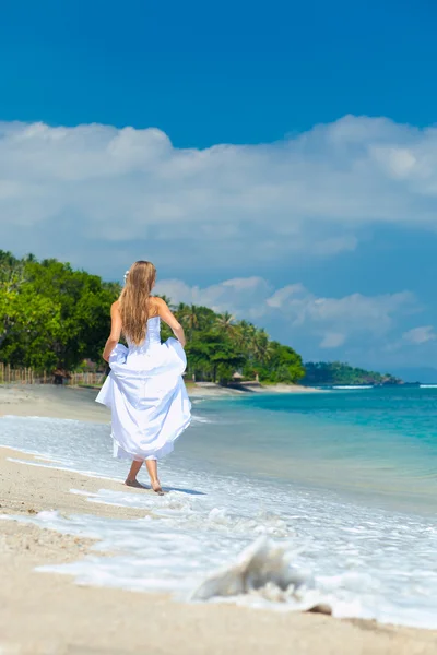 Bride walking along sea coast — Stock Photo, Image