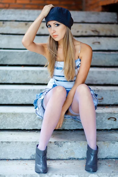 Молодая женщина сидит на ступеньке — стоковое фото