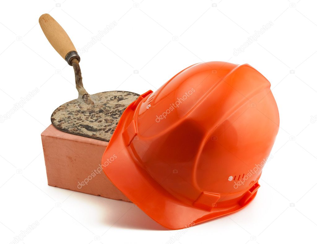 Orange helmet red brick and rusty bricklayer's trowel