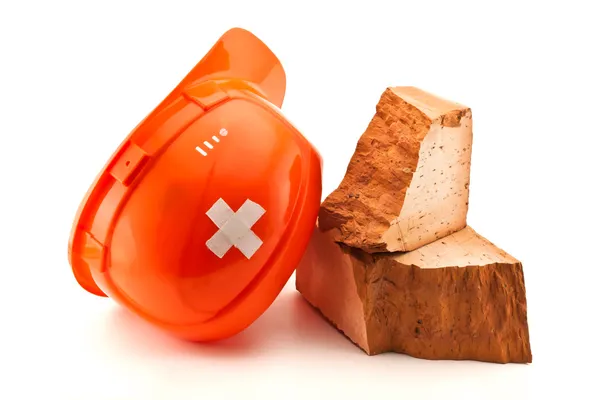 Orange helmet with cross shaped court plaster and broken brick — Stock Photo, Image