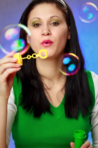 Жінка дме мильні бульбашки — стокове фото