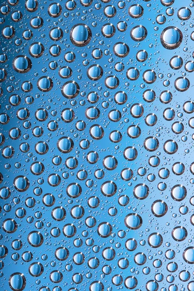 Blauwe water druppels op de transparant glas — Stockfoto