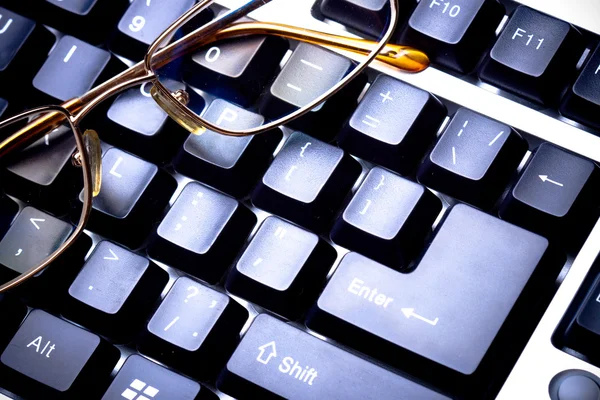 Синяя тонированная клавиатура с очками — стоковое фото