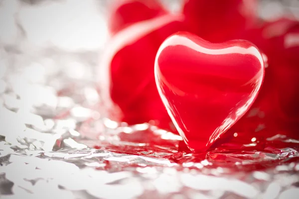 Red hearts on metal foil — Stock Photo, Image