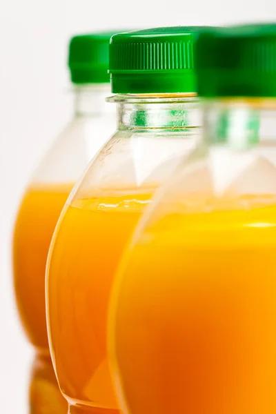 Suco de laranja três garrafas fundo — Fotografia de Stock