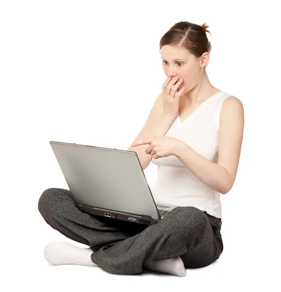 Удивлённая женщина сидит с ноутбуком — стоковое фото