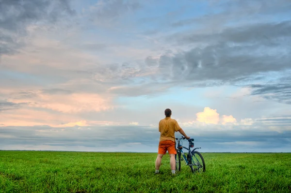 Man with bicycle looking at skies — Stock Photo, Image