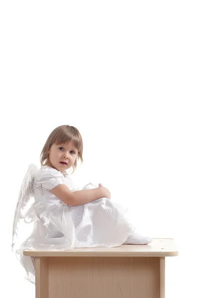 Kaide üzerinde oturan melek kız — Stok fotoğraf