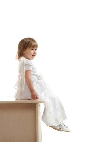 Маленькая девочка сидит на пьедестале — стоковое фото