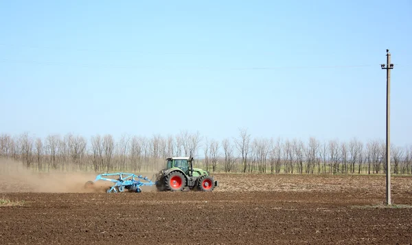 El tractor procesa la tierra —  Fotos de Stock